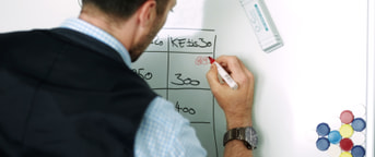 Mann schreibt auf Whiteboard Mann schreibt auf Whiteboard